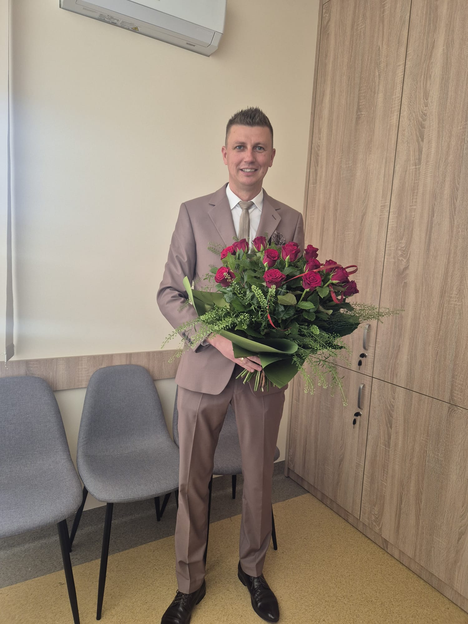 Wójt Gminy Godziesze Wielkie z bukietem czerwonych róż